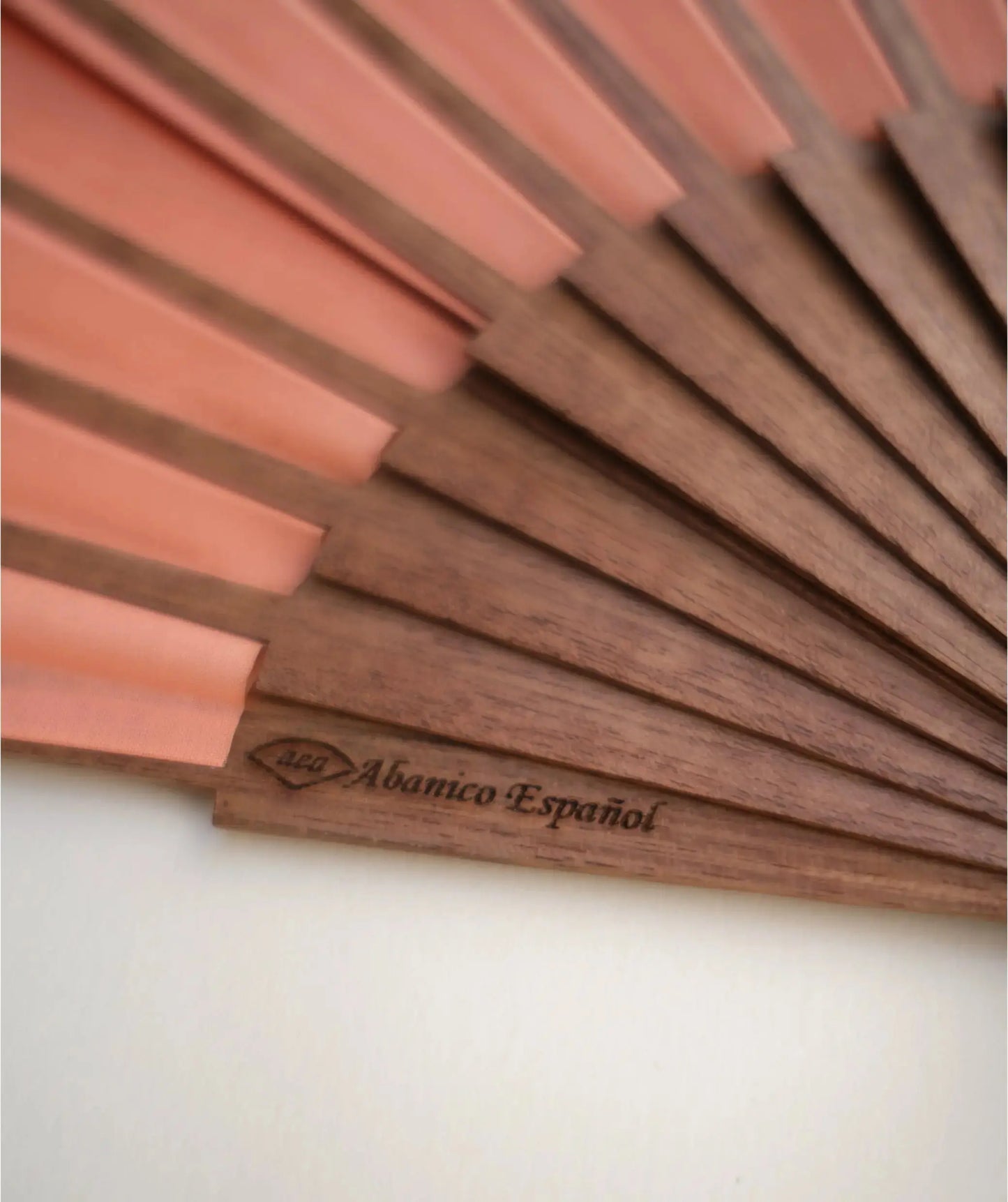 Abanico color coral / rosa. Hecho con madera de mongoy. Abierto con sello de abanico español AEA. Marca rafega.