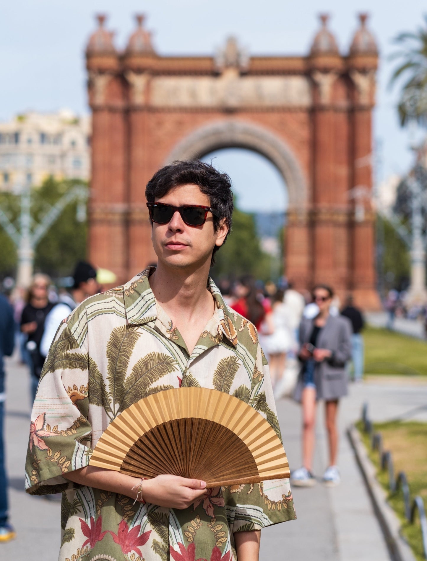 Hombre vistiendo abanico color camel / beige frente al arco del triunfo en Barcelona