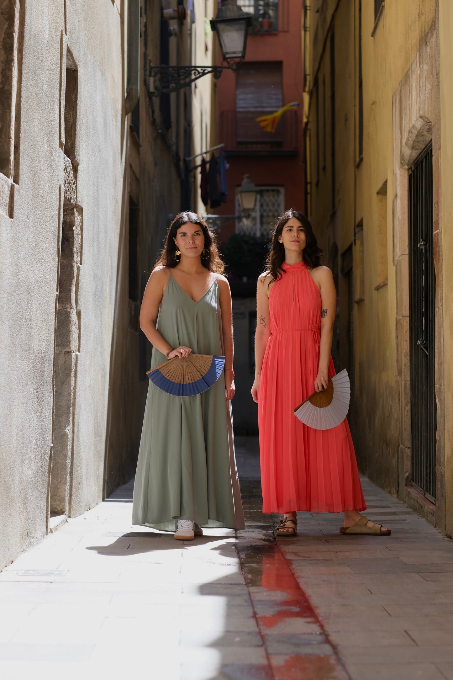 Dos mujeres con abanicos. Colores azul marino y azul claro. Ubicadas en calle del barrio Born en Barcelona.